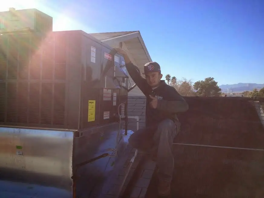 HVAC technician performing AC Tune-Up on a rooftop unit in Felida